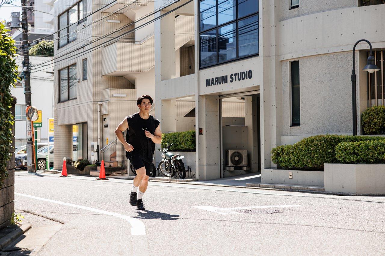 スタジオ前の道を走る男性
